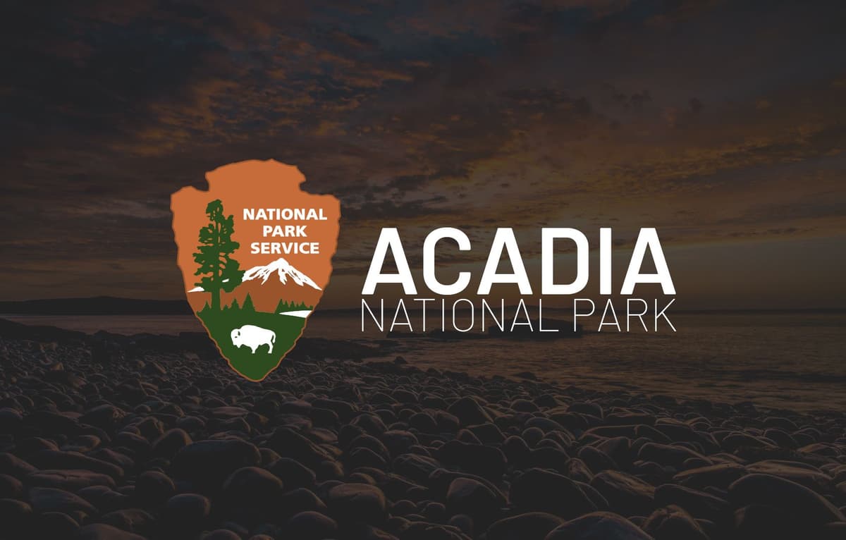 The national park service logo superimposed over a picture of a sunrise.